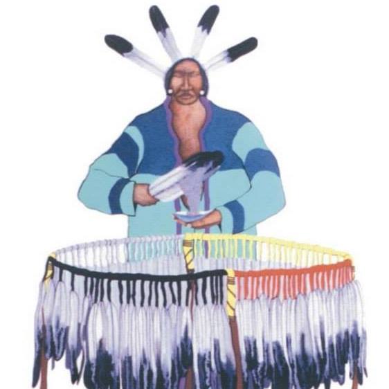 Indigenous person standing behind a hoop of eagle feathers